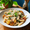 A cheesy pasta dish topped with fresh basil