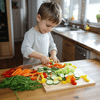 A child cutting vegetables with a plastic knife on a cutting board